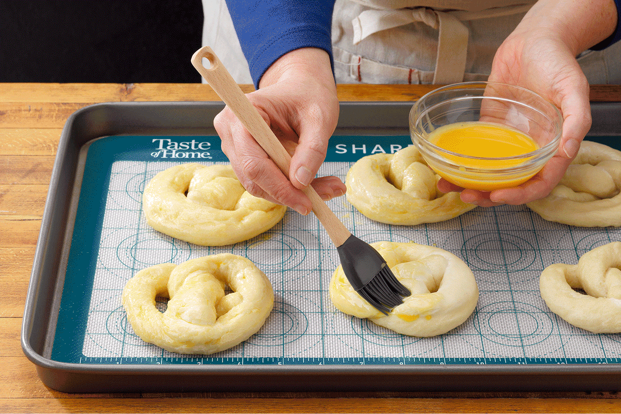 Brushing the pretzels with egg whites and sprinkling salt on it