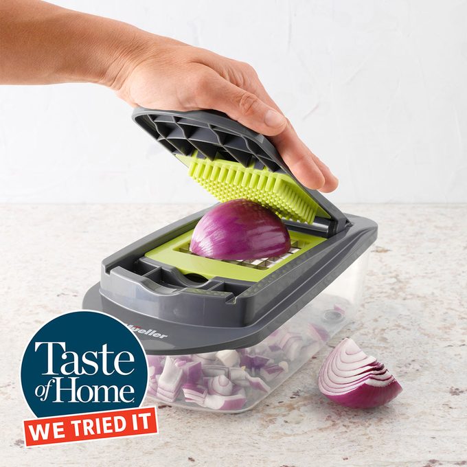 Hand Chopping Onion With Mueller Veggies Chopper in white kitchen