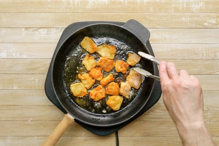 Cooking the coated chicken pieces