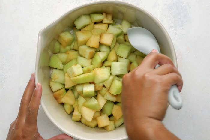 Mixing the apples in a bowl