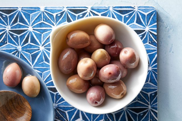 Beldi olives in a dish on patterned surface background