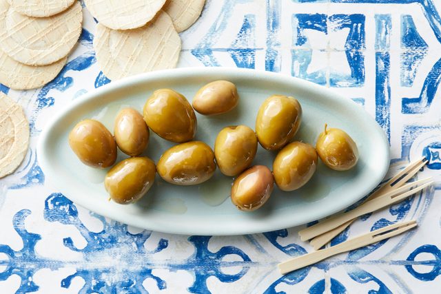 Gordal olives on an oval dish on blue and white background