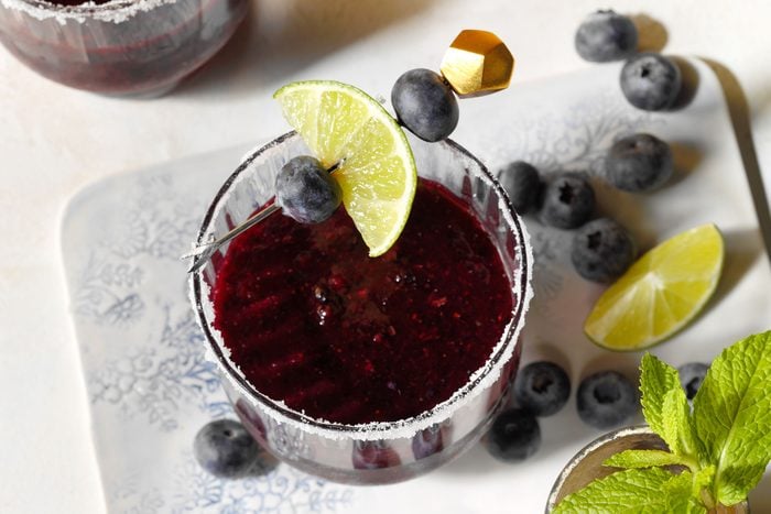Blueberry Margarita served in glassed with garnished lemon wedge and blueberries on the rim