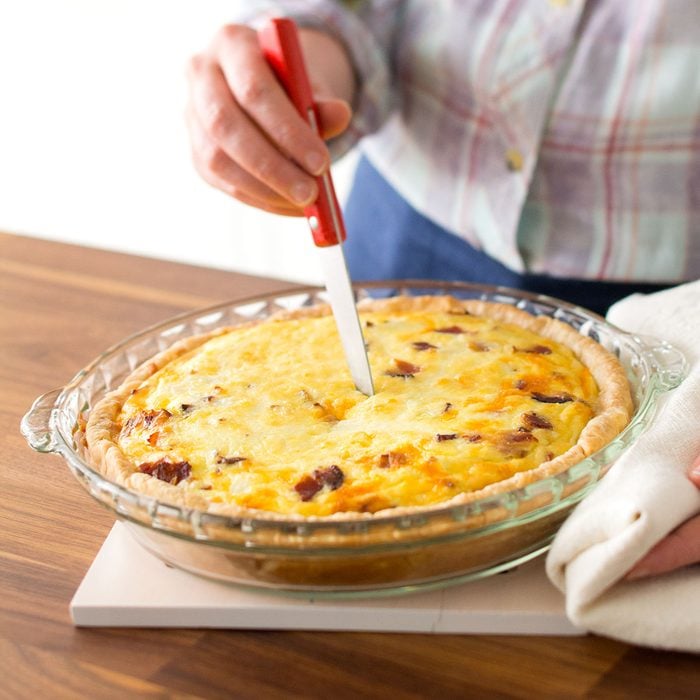 Checking the baked quiche with knife