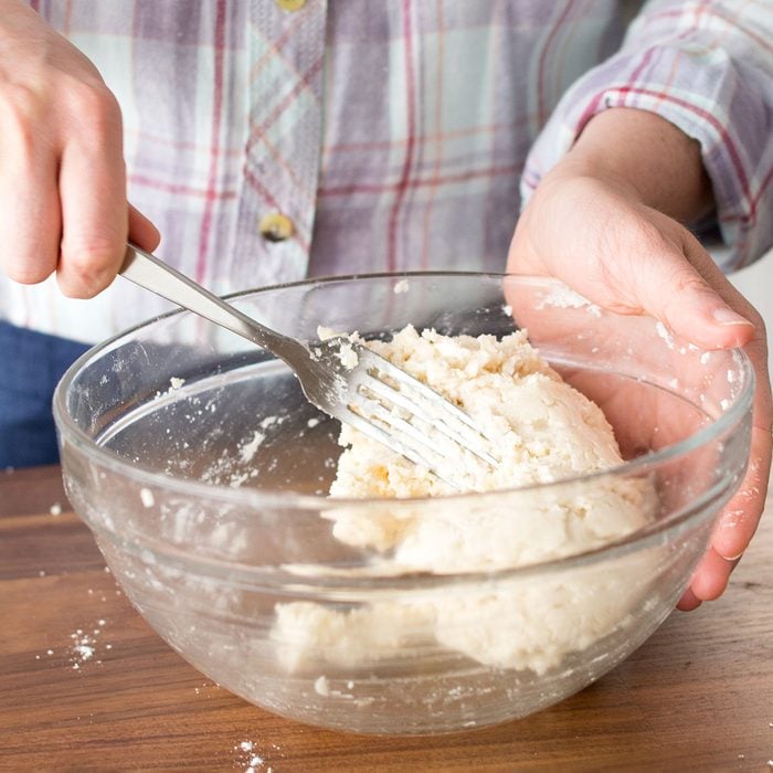 mixing dough with fork in a bowl