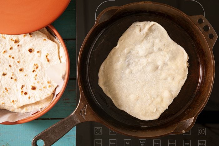 Tortillas in a skillet on a table.