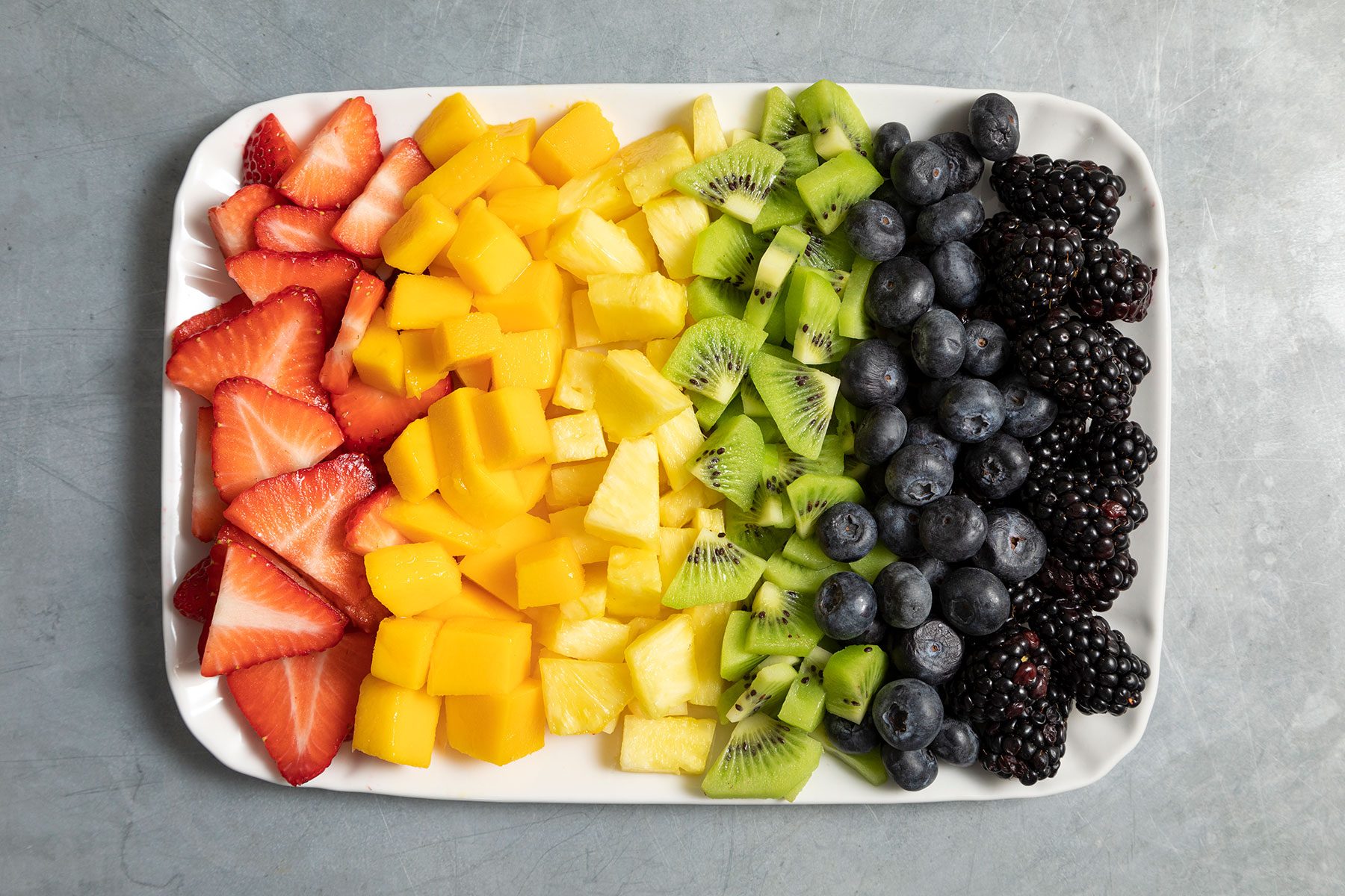 Pieces of fruits lined up on tray