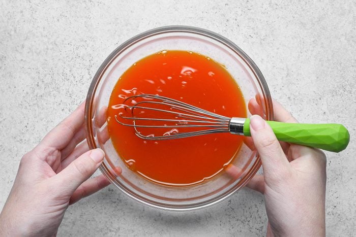A person mixing Pickle Juice with a whisk