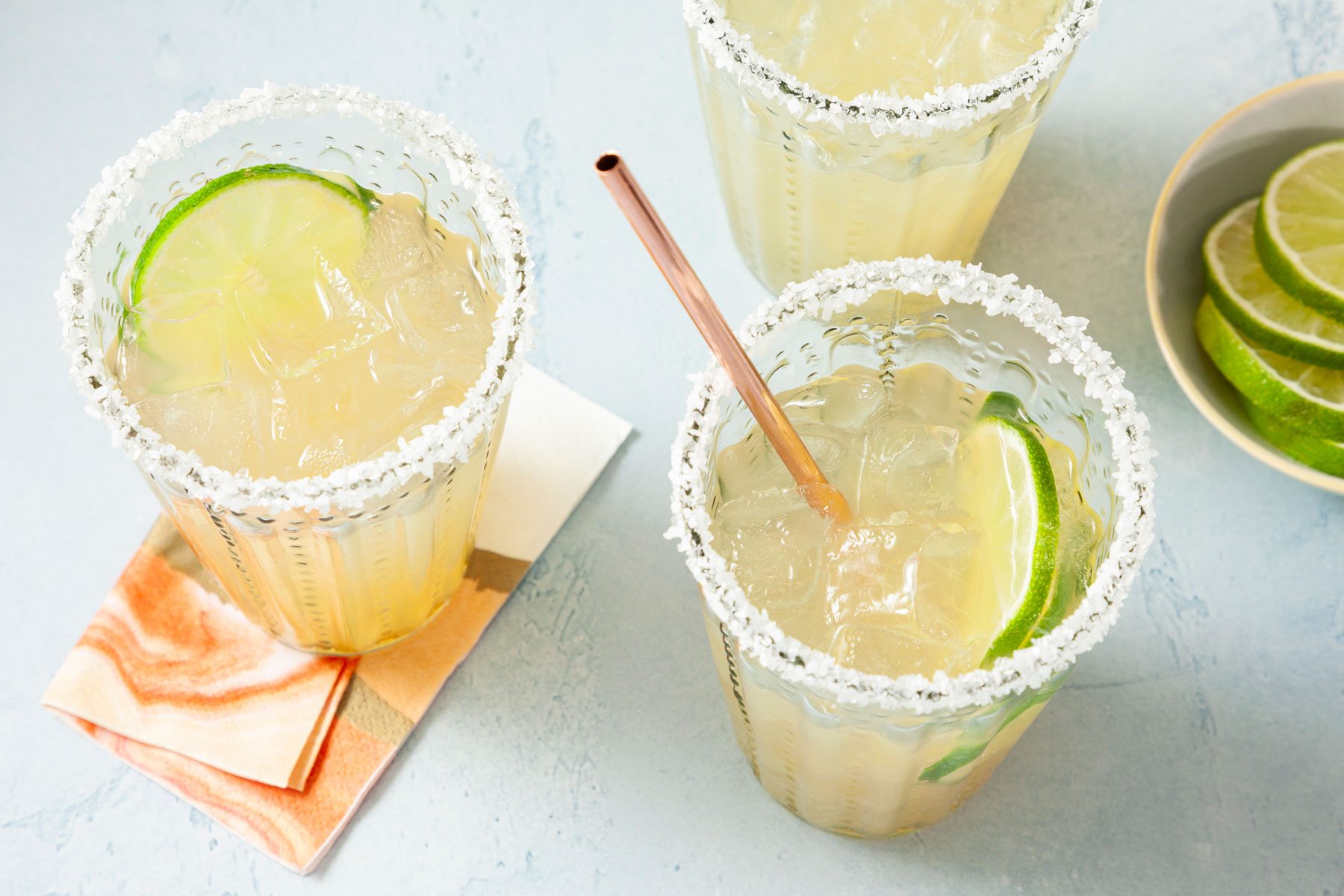 Refreshing Beer Margaritas in cups with a straw and lemon on side