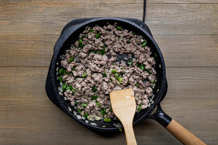 Cooked sausage, onion and green pepper in a large skillet with. wooden spatula