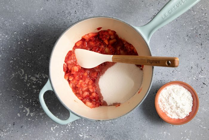 mashed strawberries with sugar in sauce pan