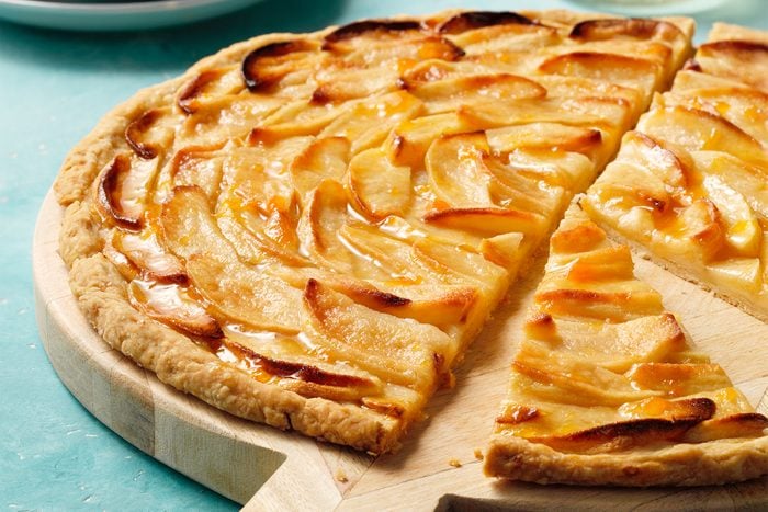 A slice of apple tart on a wooden pizza board