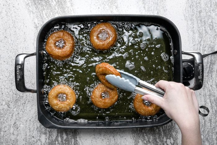 Frying the doughnuts until golden brown