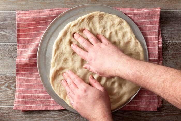 Pat the dough onto a greased 14-inch pizza pan