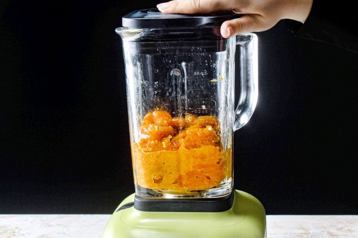 Apricot mixture in a blender placed on a marble contertop