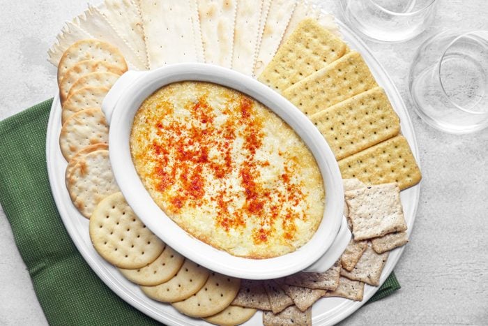 Artichoke Dip served with crackers in a large white plate
