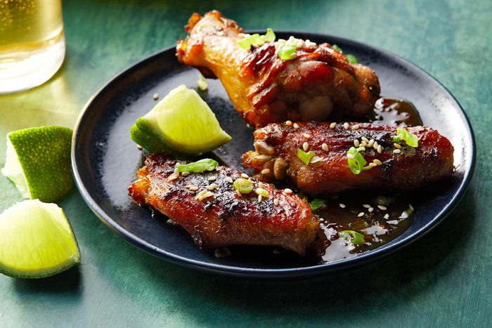 Asian Chicken Wings served on plate with lemon wedges 