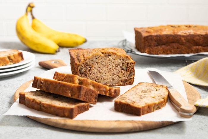 Slices of Banana Pineapple Bread served on a wooden tray with a knife