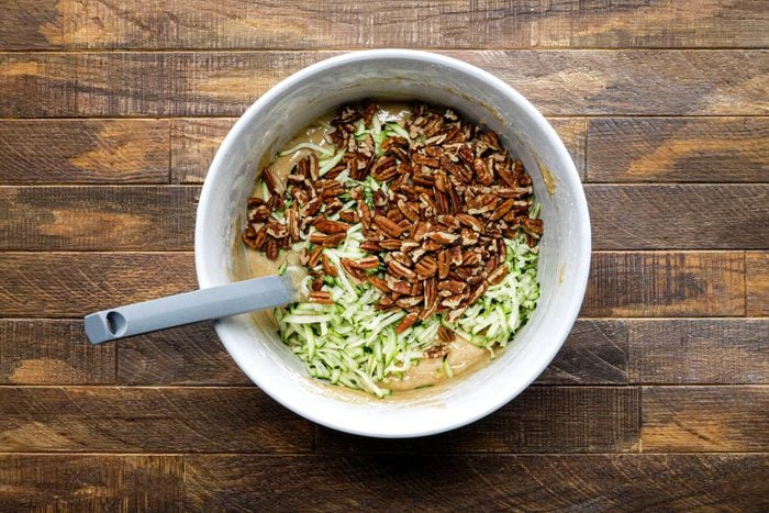 Pour the zucchini and pecans into the batter in a bowl