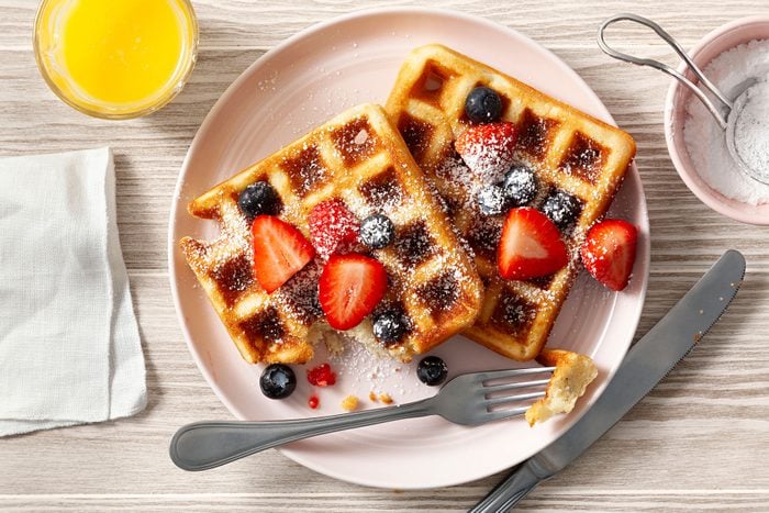 Belgian Waffles topped with fruits and served on plate