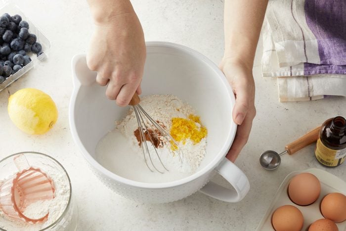 Whisking the flour, sugar, baking powder and other ingredients in a large bowl.