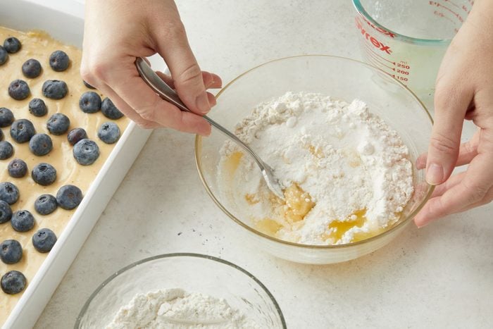 Whisking together the sugar and flour with a spoon in a small bowl.