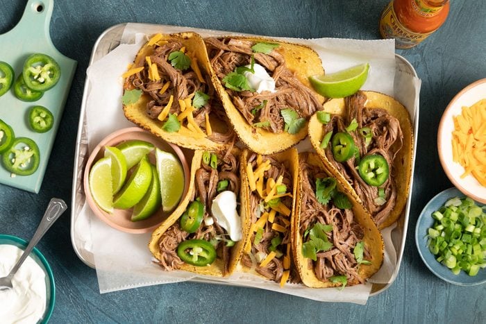 Brisket Tacos topped with lemon, jalapeños and cheese and served on plate