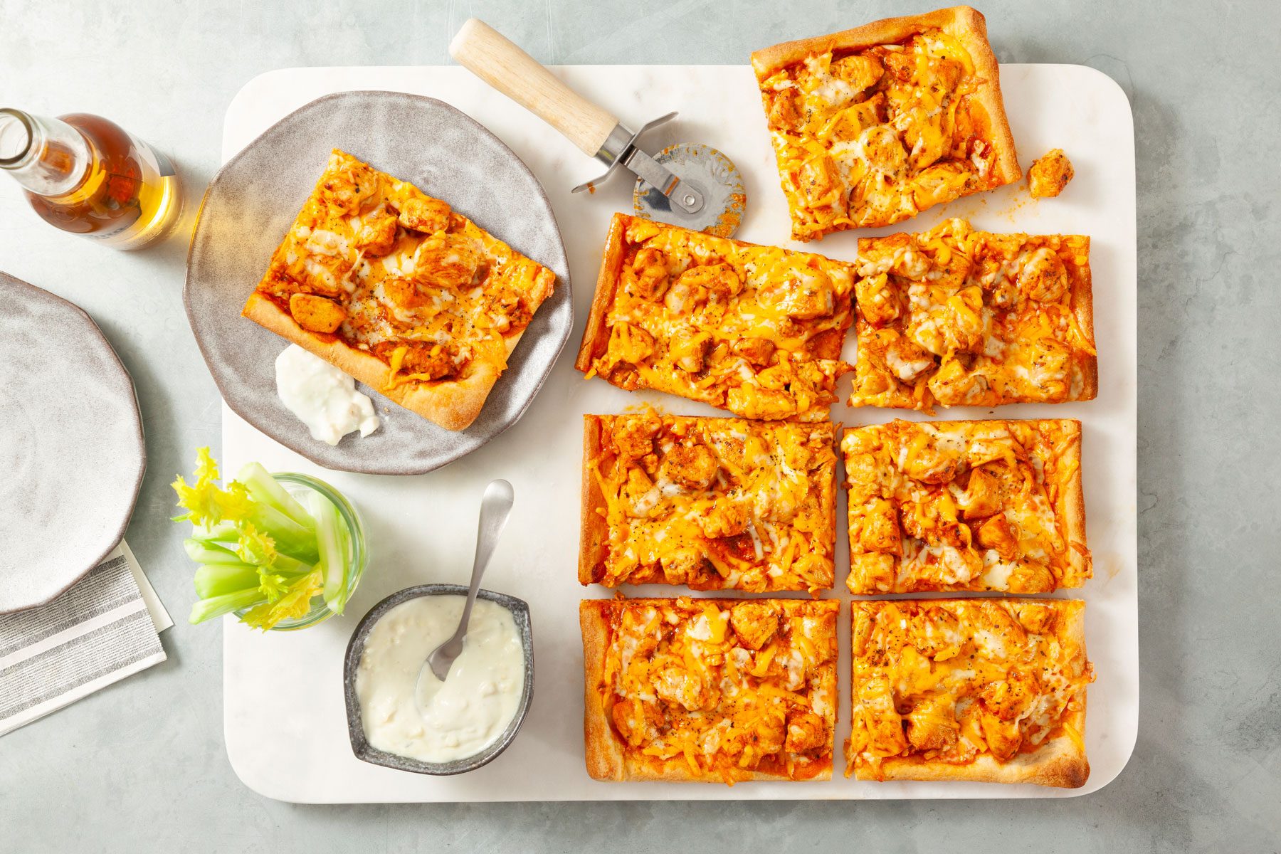 Slices of Buffalo Chicken Pizza served in a plate with a drink