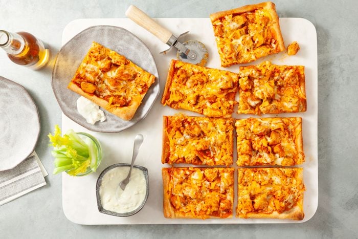 Slices of Buffalo Chicken Pizza served in a plate with a drink
