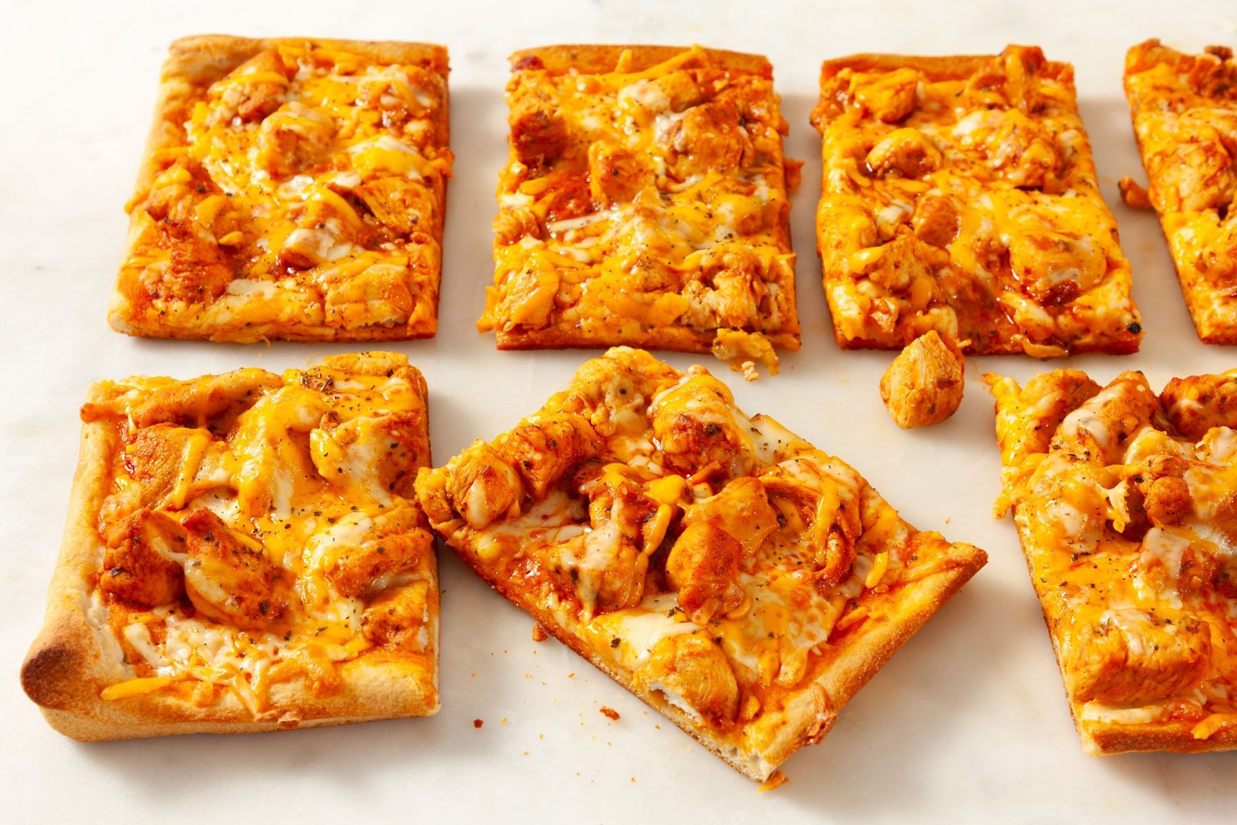 Slices of Buffalo Chicken Pizza on a white surface