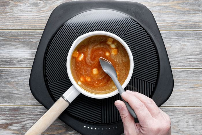 Cooking the sauce in a small white pan, mixing with spatula