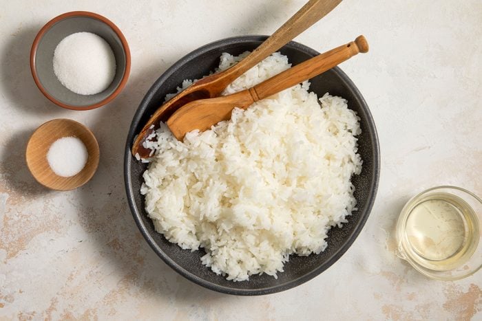 Cooked rice in a bowl with wooden spoons
