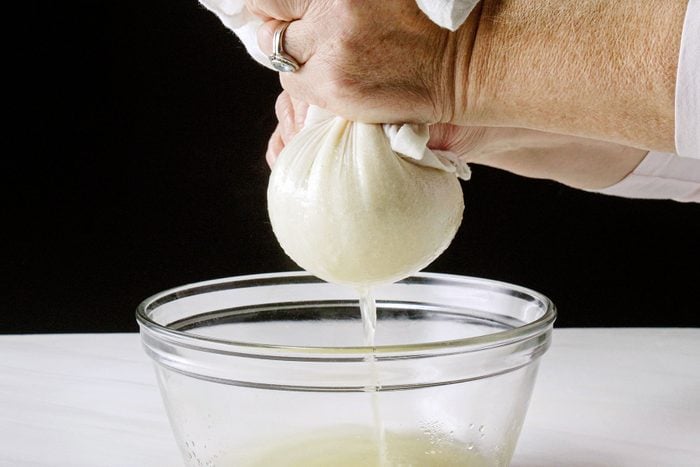 Squeezing the water out from chopped cauliflower in muslin cloth