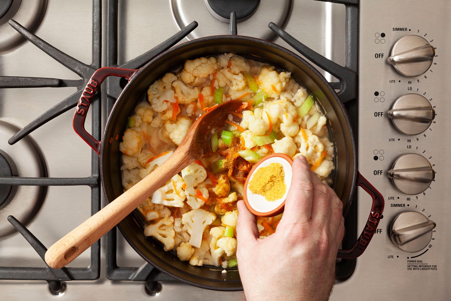 Boiling the cauliflower, carrot, celery in a large dutch oven