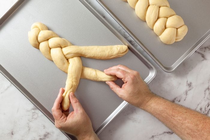 Braiding ropes of dough on baking sheet