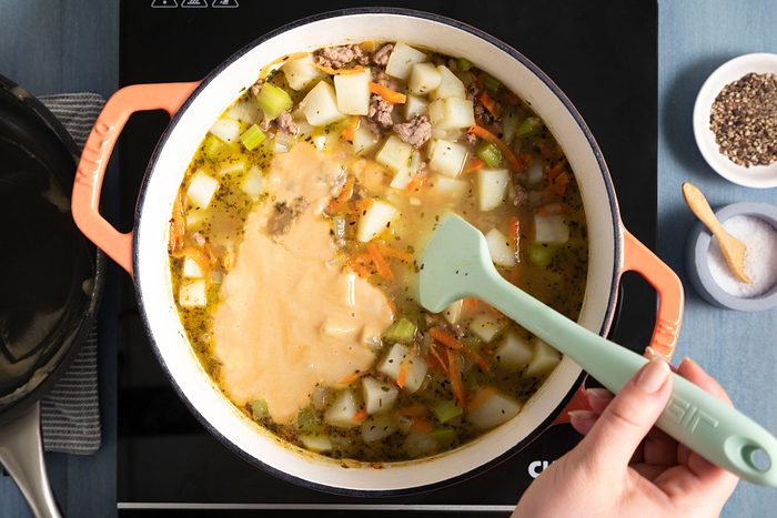 Stirring the roux mixture in soup 