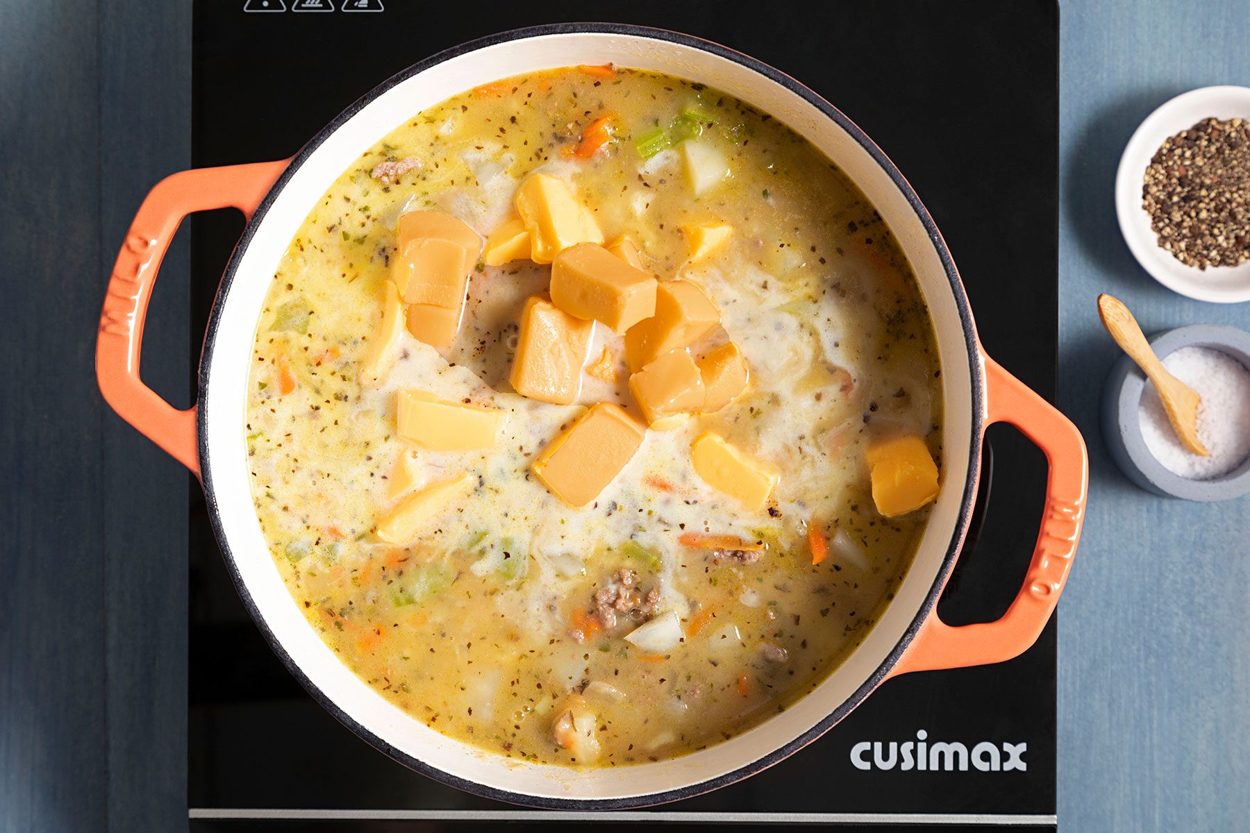 Cheese cubes melting in pot full of soup