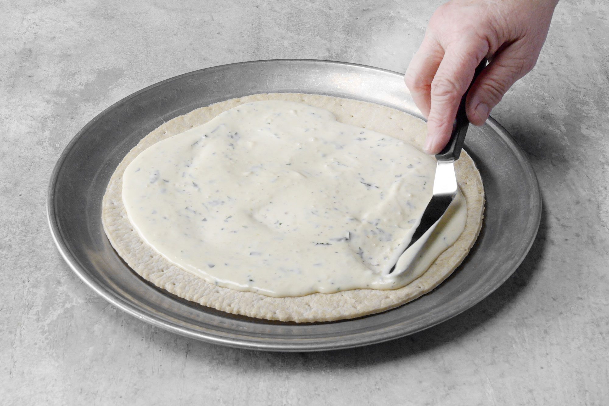 Spread the Alfredo sauce on pre-baked pizza crust
