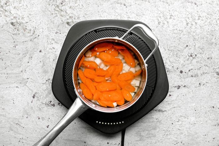 Potatoes and carrots in water for boiling in a small saucepan.