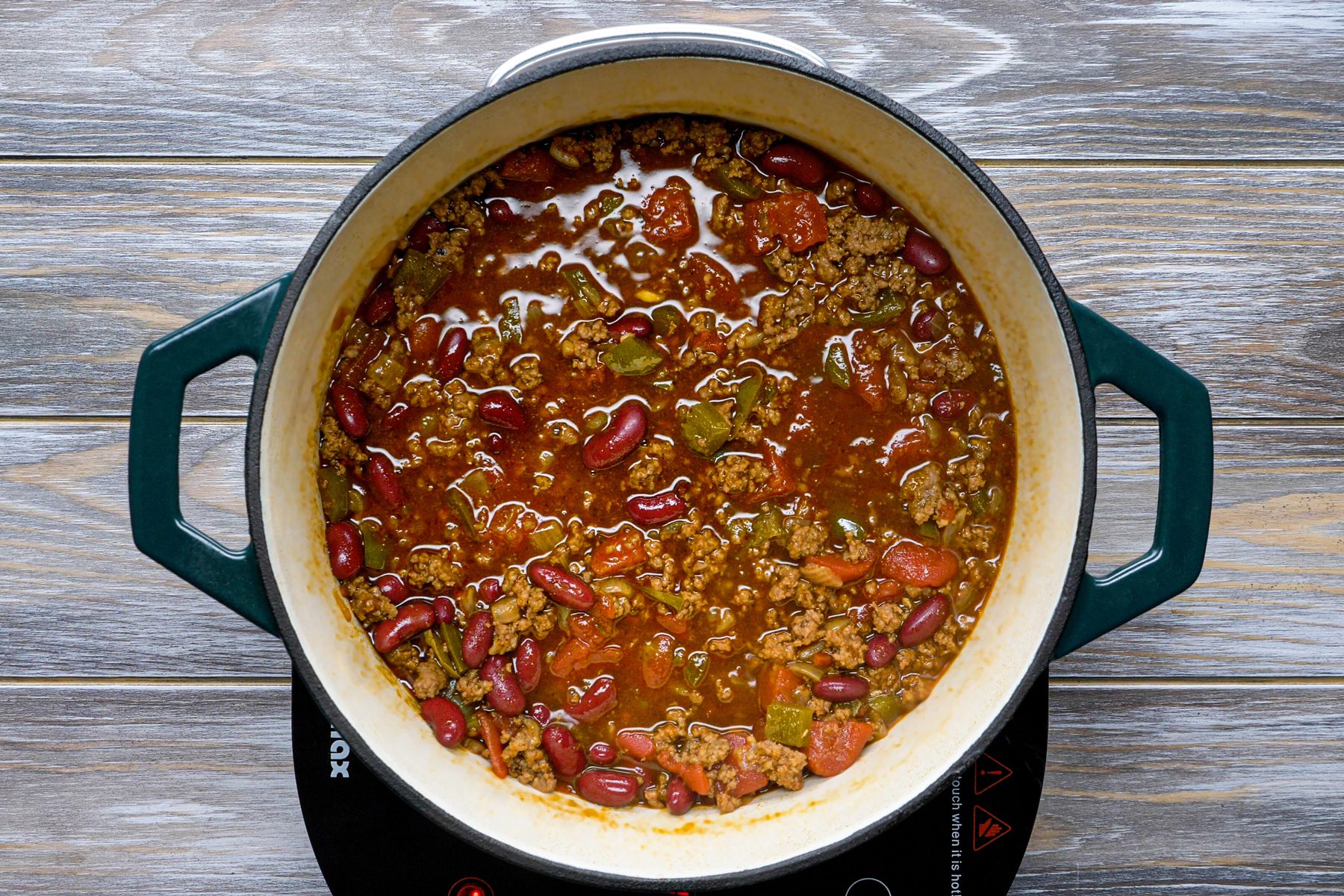 Ground beef, vegetables and beans cooking in a Dutch oven