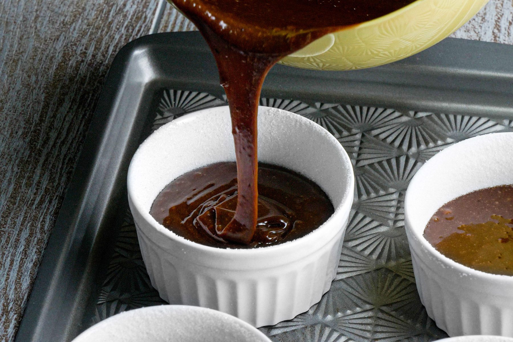 Melted chocolate being poured into a small white dish