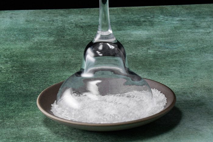 An overturned glass on a plate with salt scattered around it