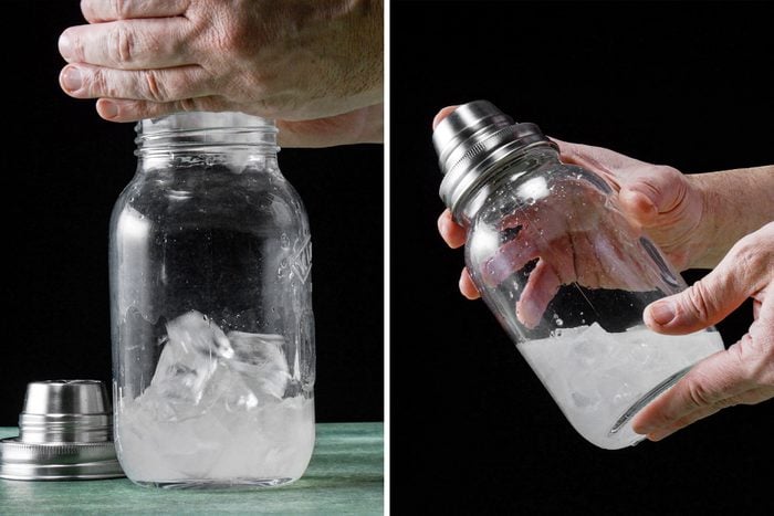 A person preparing a cocktail using a shaker filled with ice.