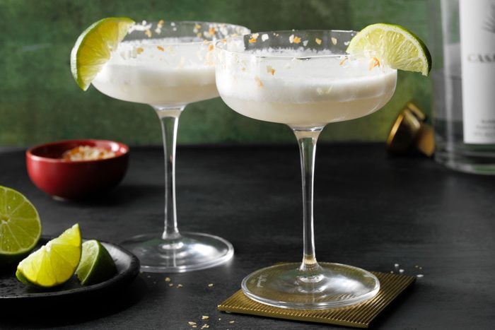 Coconut Margarita blended in large stem glass with lime