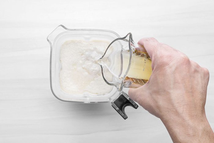 Pouring vanilla extract in a blender 