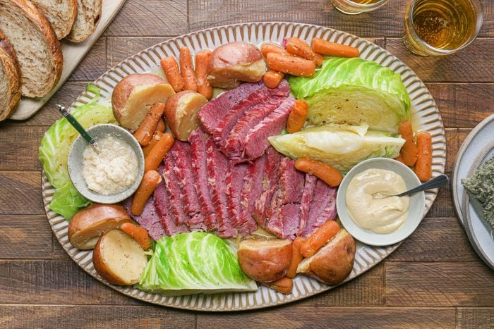 Corned Beef And Cabbage served in a plate with sauce in small bowls