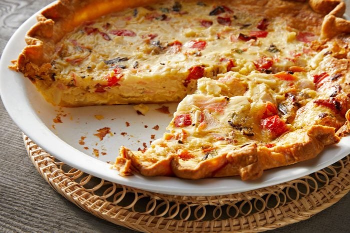 Crab Quiche on a White Pie Plate on Wooden Surface