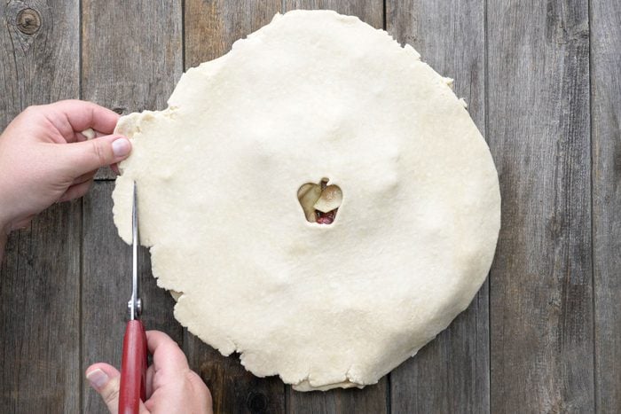 A person Trimming the edges on dough on the pie crust