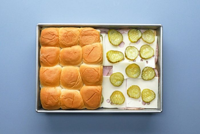 Ham, cheese pickles and rolls in a large baking pan