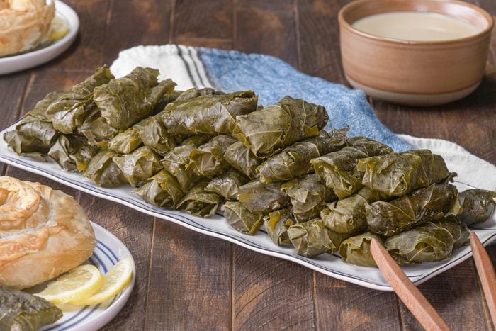 Dolmades With Avgolemono Sauce served in a plate on a wooden table
